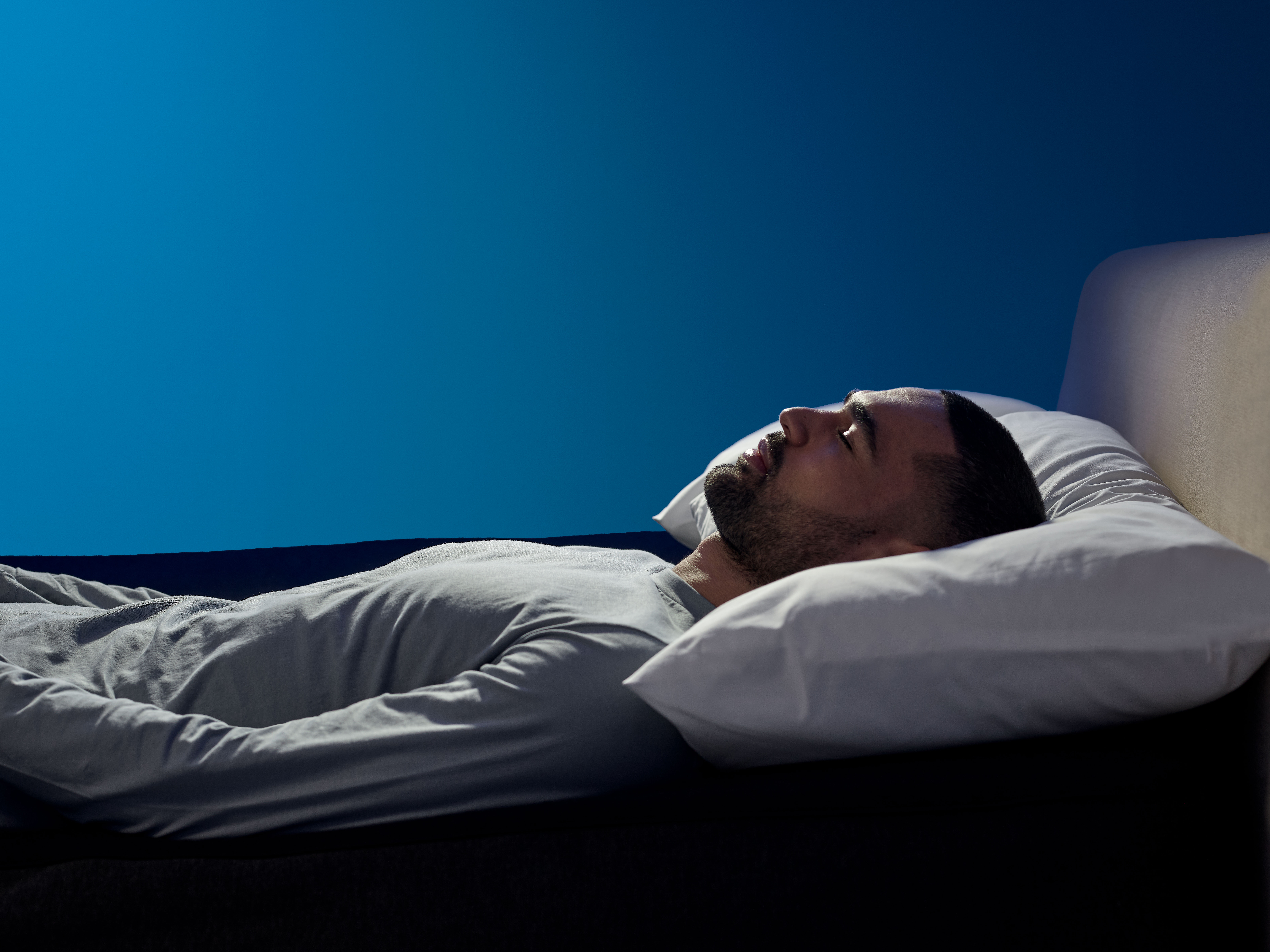 A man sleeping on a bed with a pillow