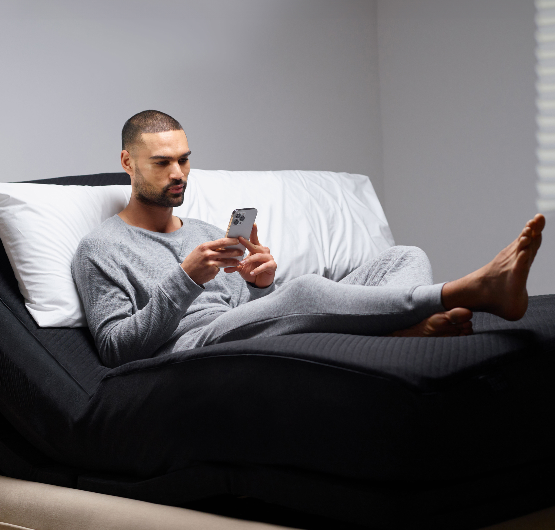 A man lying on the Pod 4 Ultra looking at his phone.